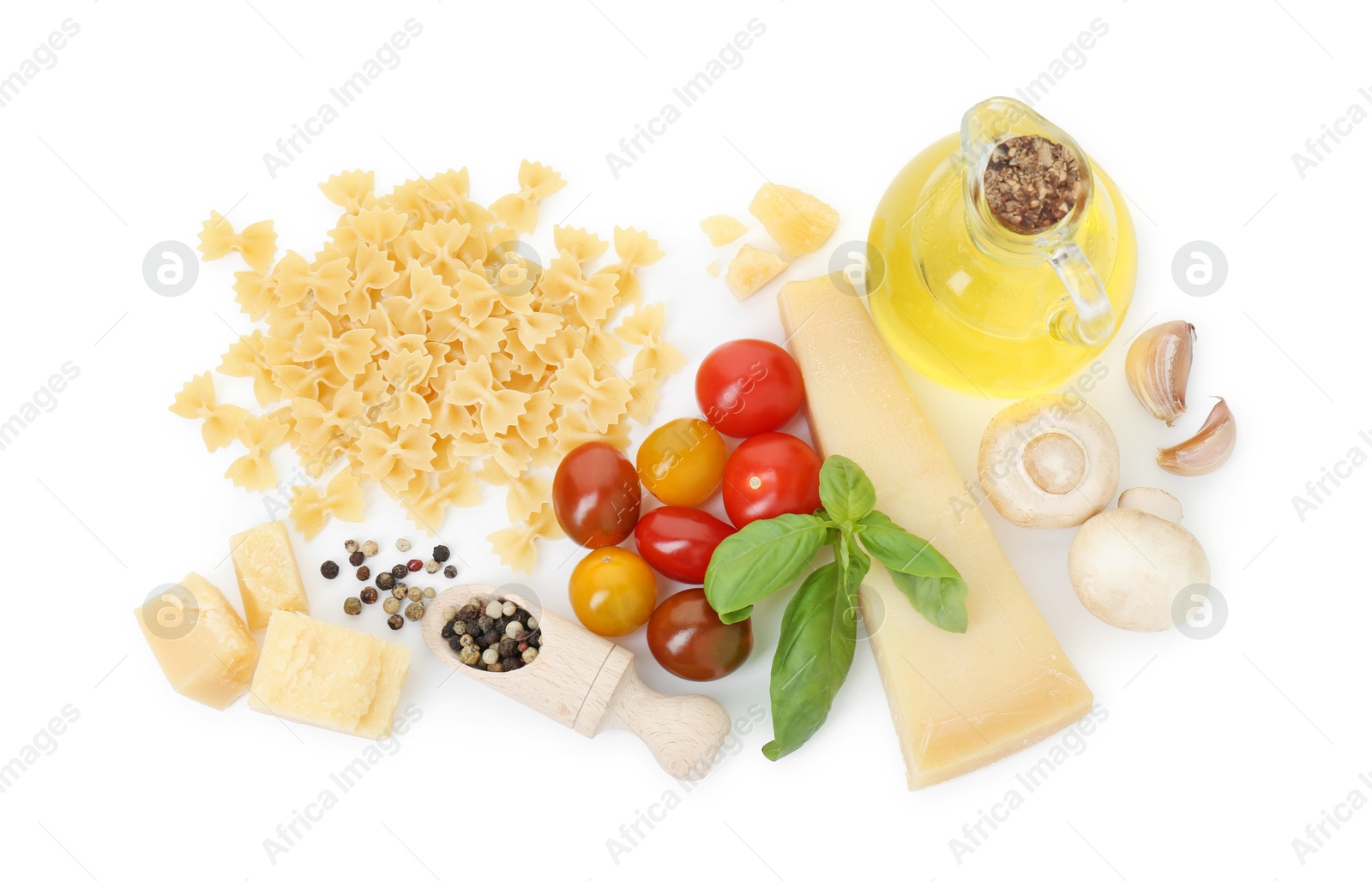 Photo of Uncooked farfalle pasta and ingredients on white background, top view