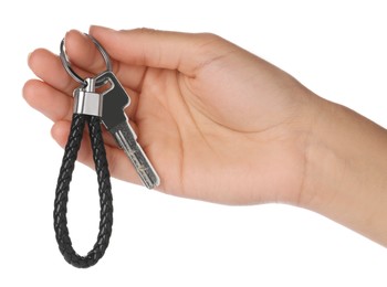 Woman holding key with black leather keychain on white background, closeup