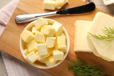 Photo of Tasty butter with dill and knife on wooden table, top view