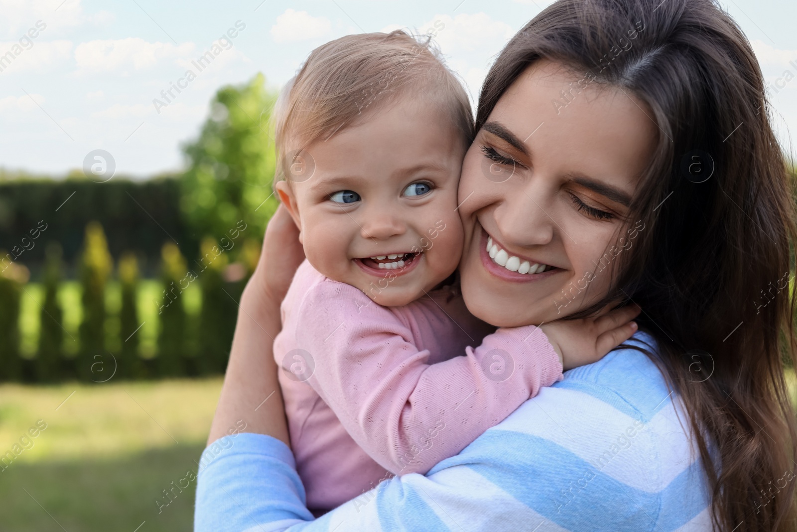 Photo of Happy mother with her cute baby at backyard on sunny day