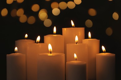 Image of Burning candles on dark background with blurred lights. Bokeh effect
