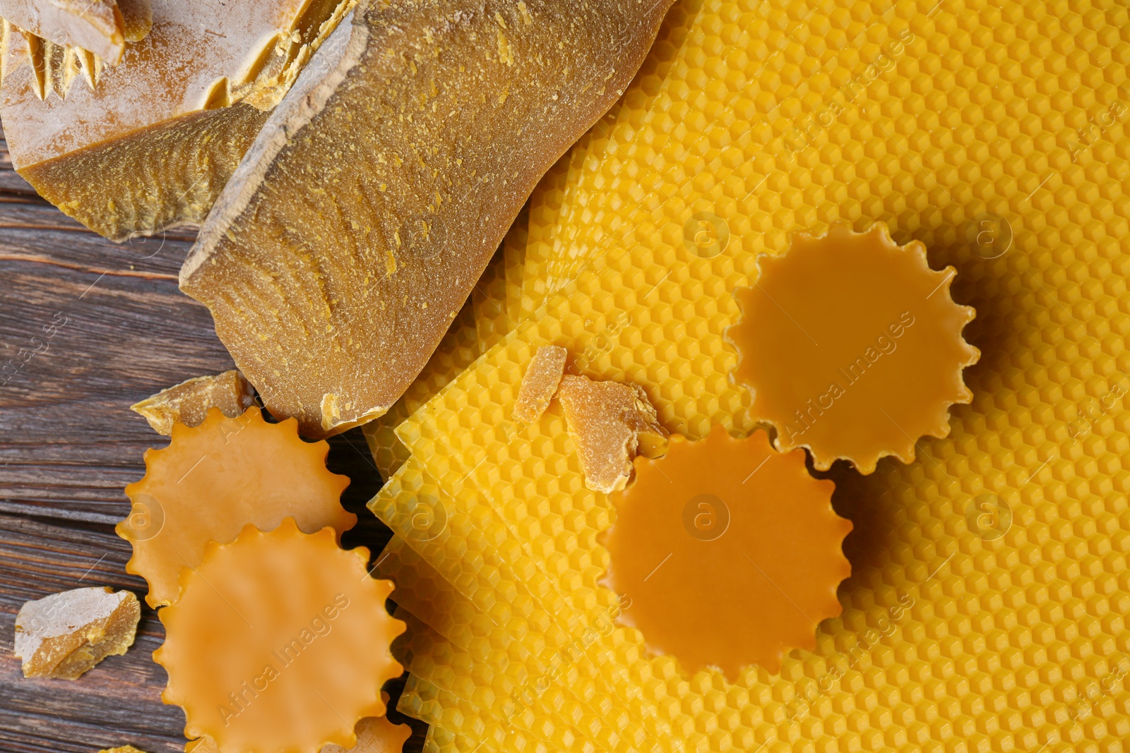 Photo of Different natural beeswax blocks and sheets on wooden table, flat lay