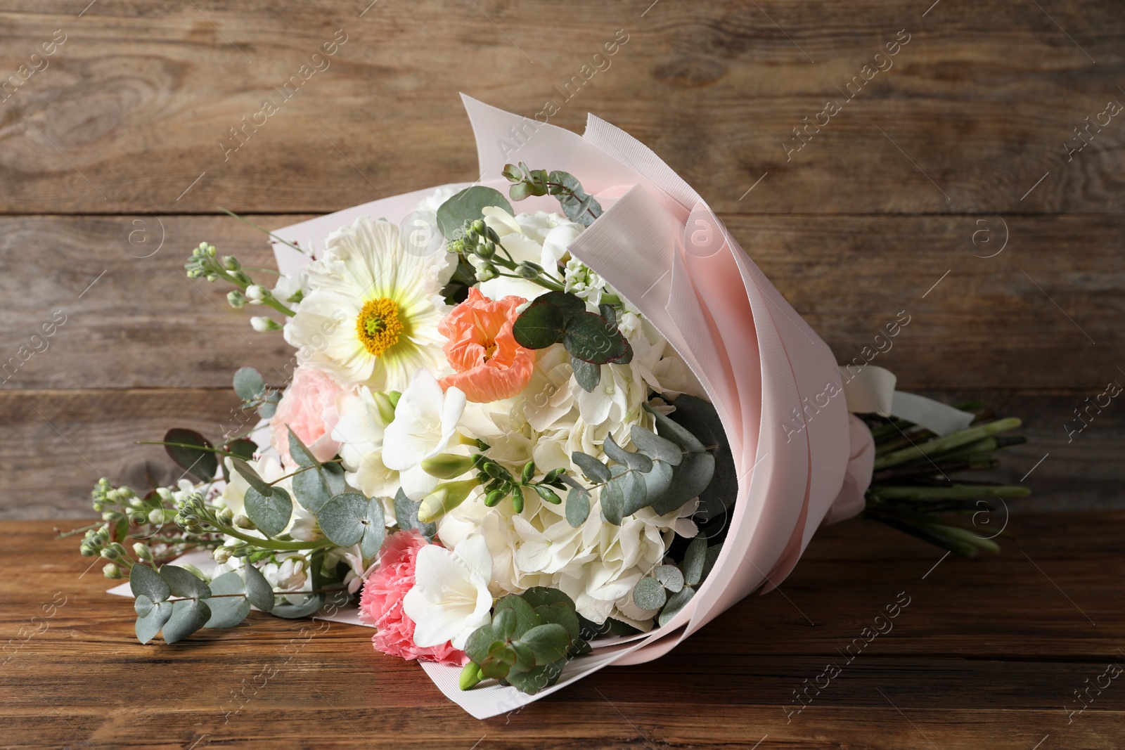 Photo of Bouquet of beautiful flowers on wooden table