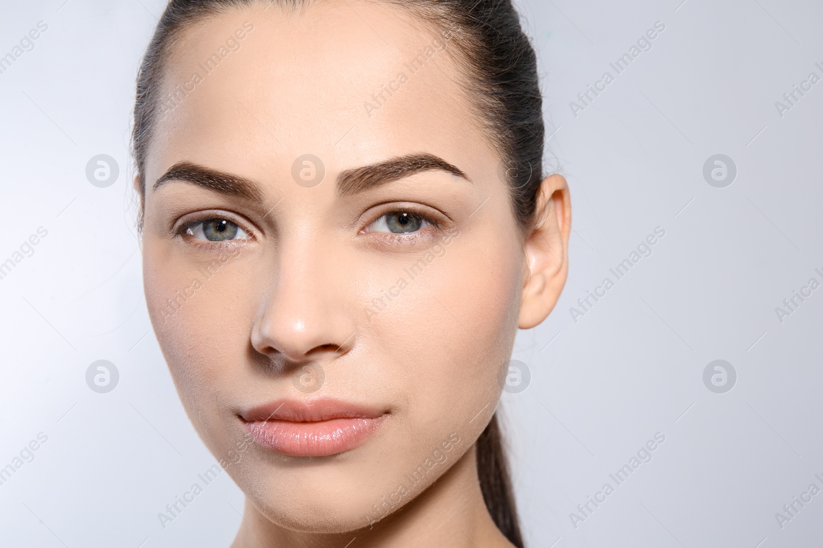 Photo of Beautiful woman with perfect eyebrows on light background