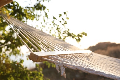 Photo of Empty hammock hanging outdoors. Time to relax