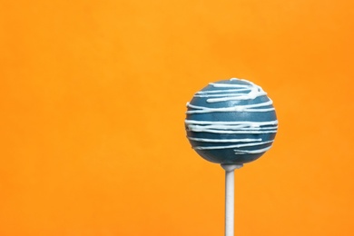 Bright delicious cake pop on color background. Space for text