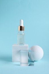 Stylish presentation of cosmetic serum on light blue background