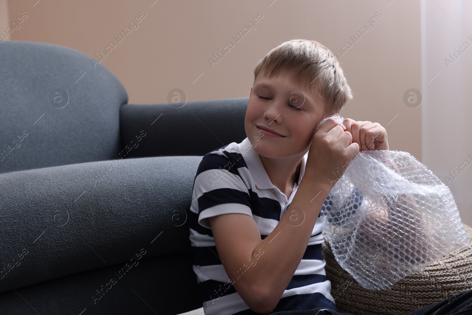 Photo of Boy popping bubble wrap at home. Stress relief
