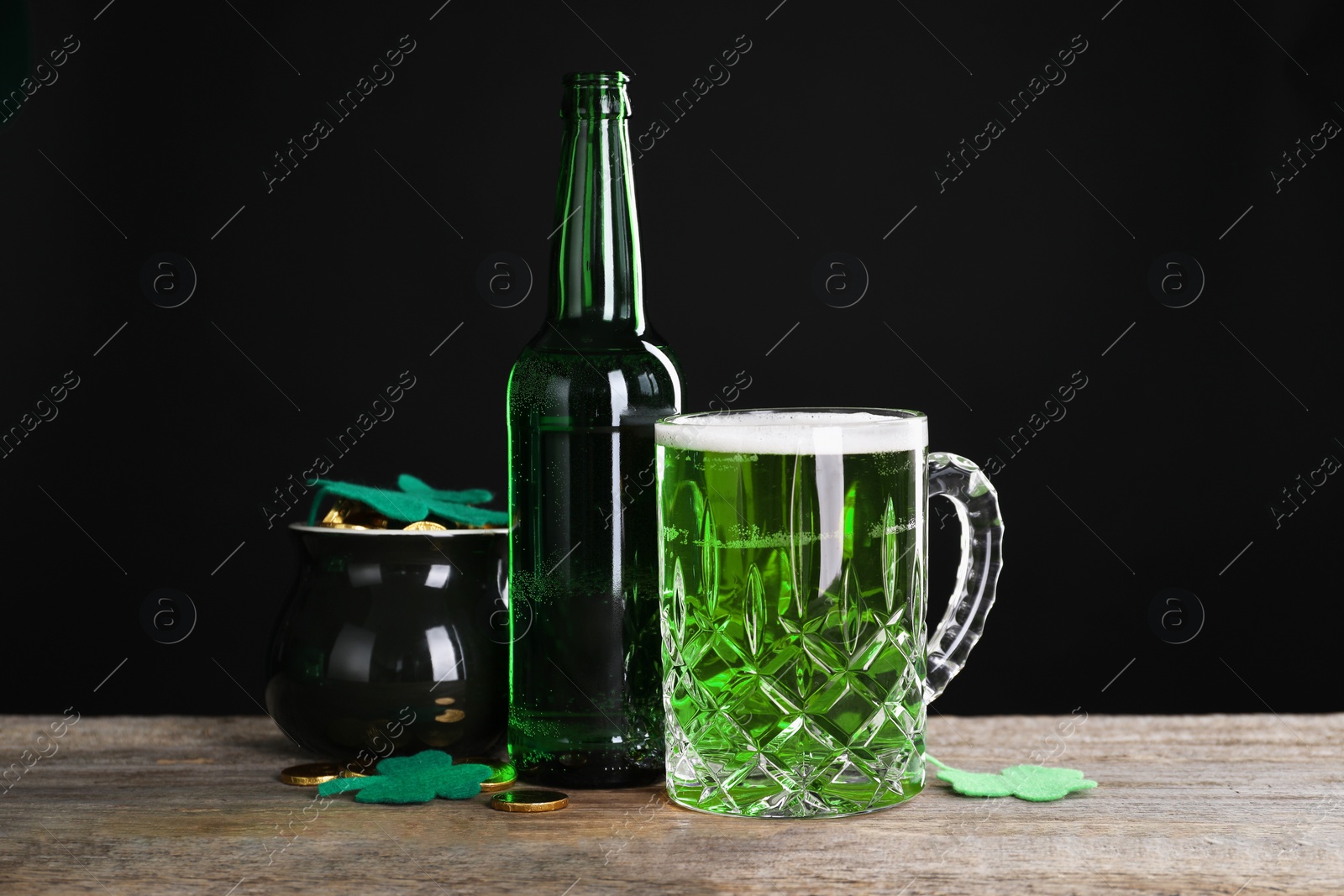 Photo of St. Patrick's day party. Green beer, leprechaun pot of gold and decorative clover leaves on wooden table