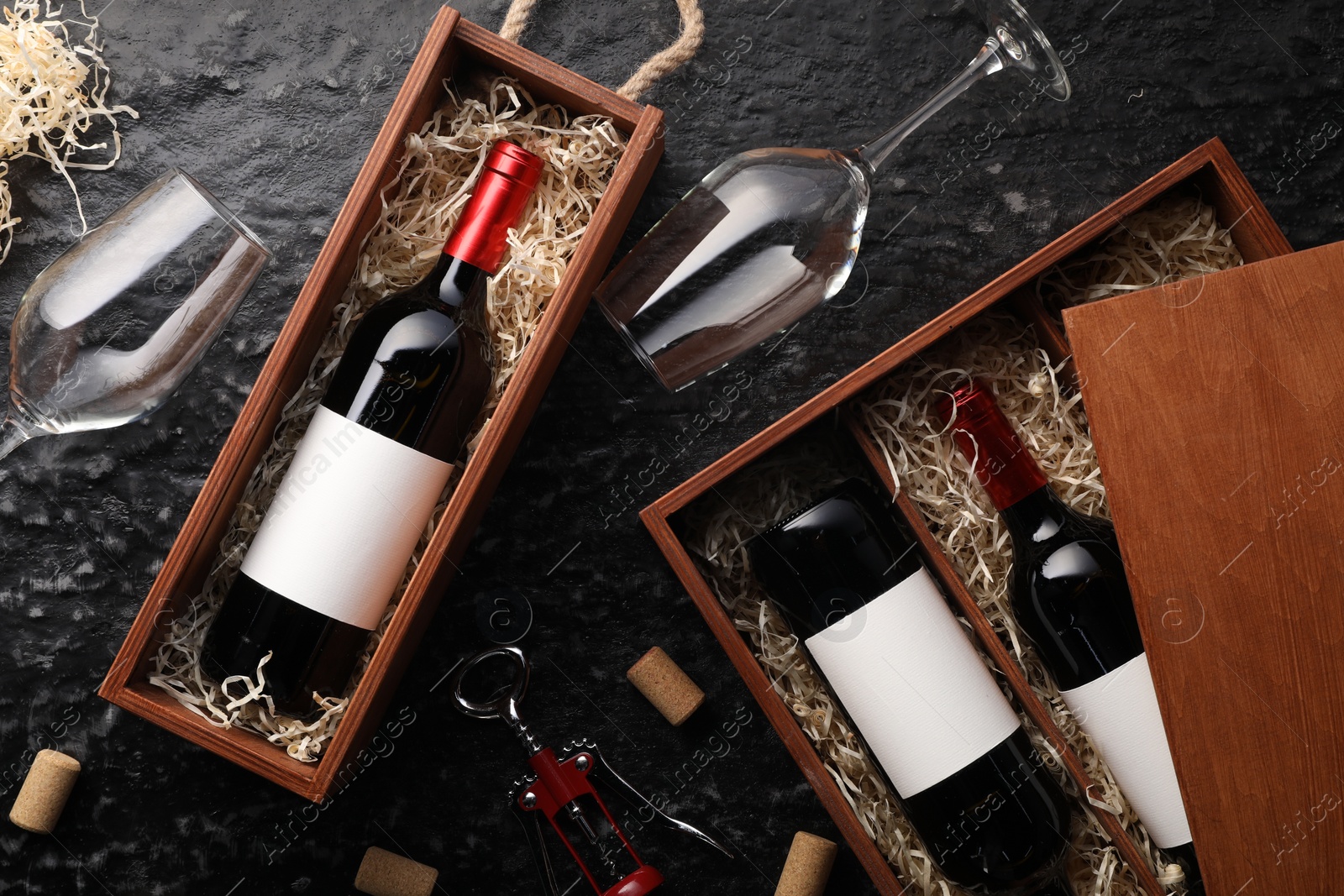 Photo of Flat lay composition with bottles of wine in wooden boxes on dark textured table