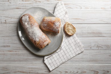 Photo of Fresh crispy ciabattas on white wooden table, flat lay. Space for text