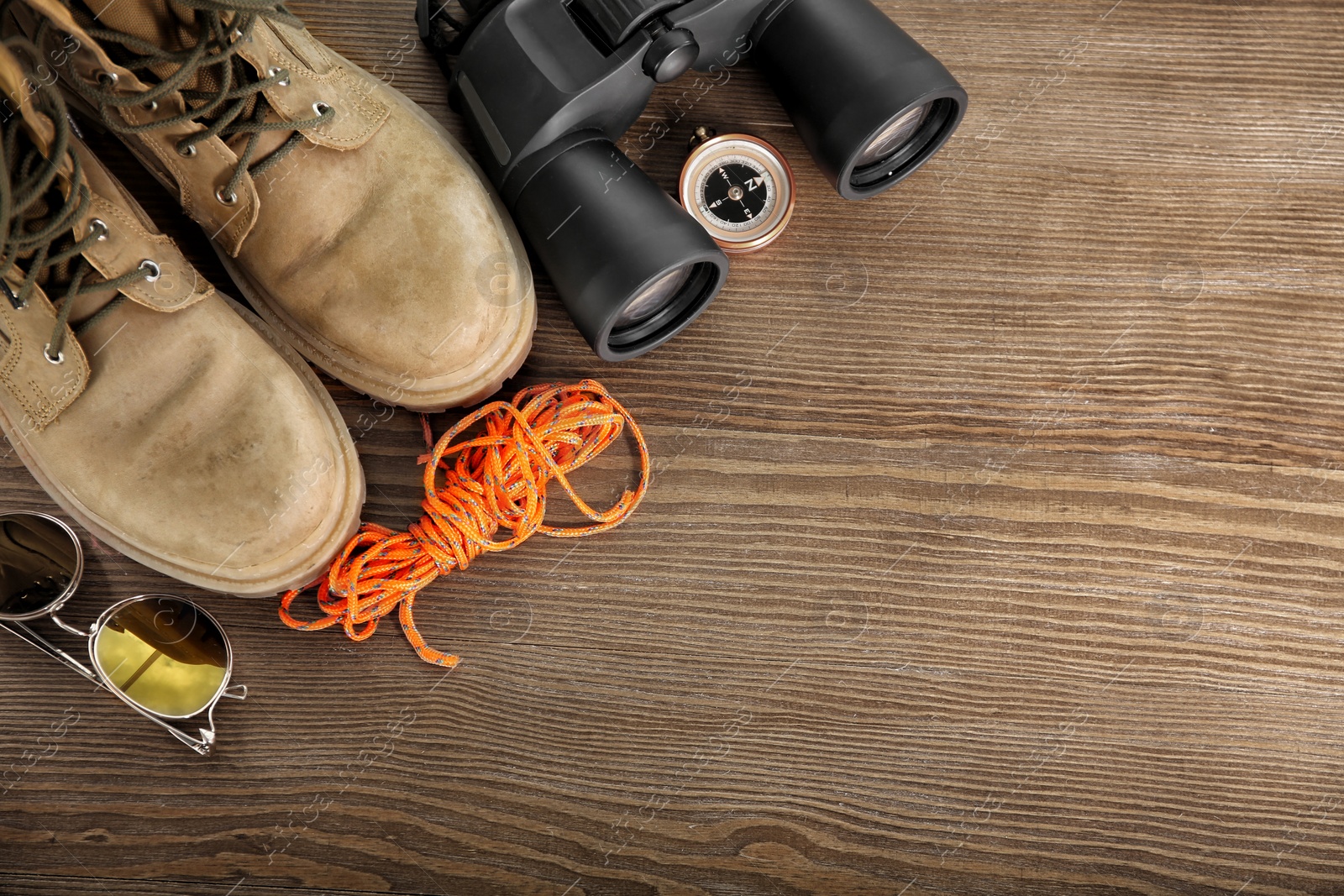 Photo of Flat lay composition with camping equipment on wooden background