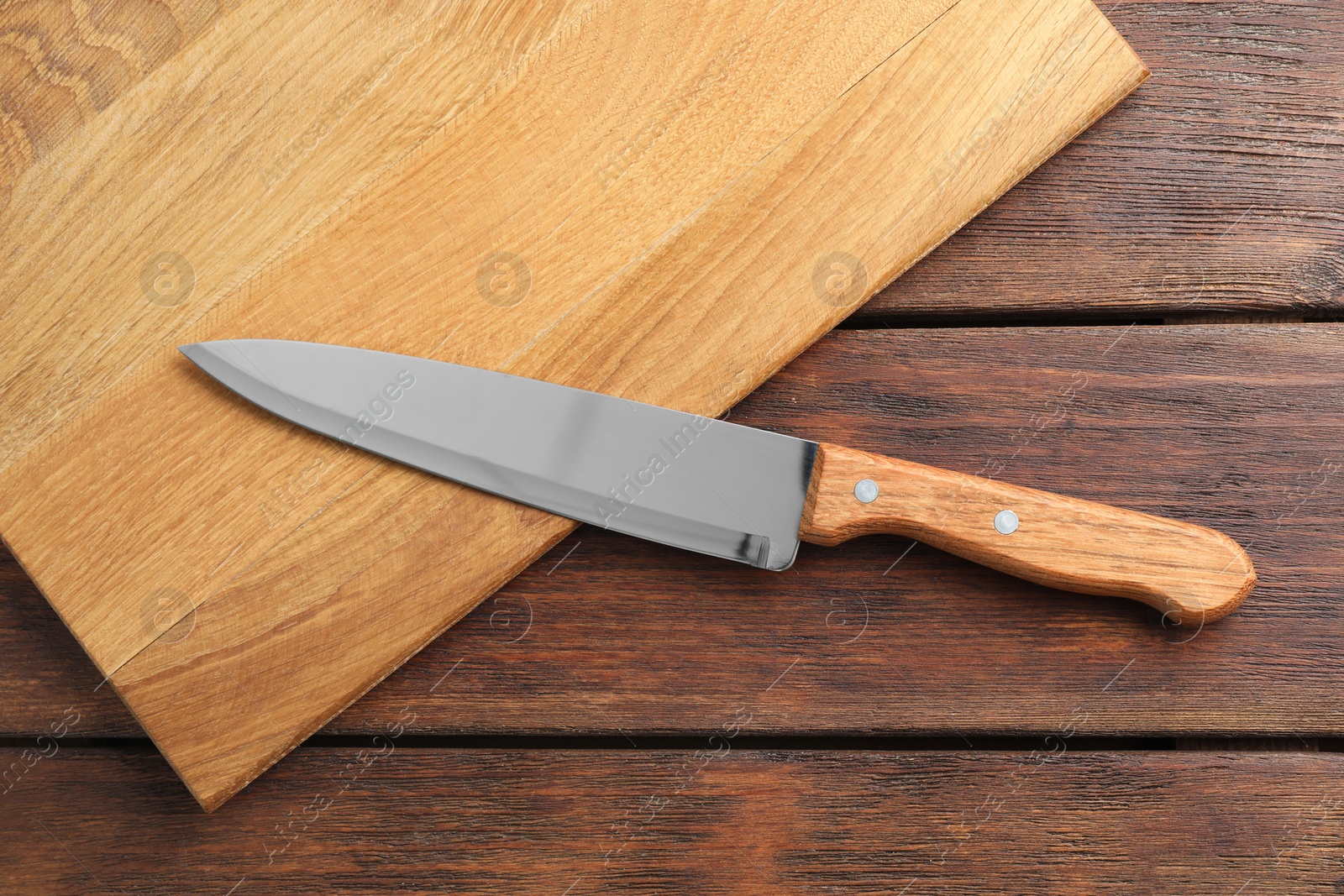 Photo of One sharp knife and board on wooden table, top view