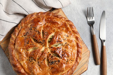 Photo of Tasty homemade pie served on light grey table, flat lay