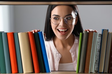 Woman searching for book on shelf in library