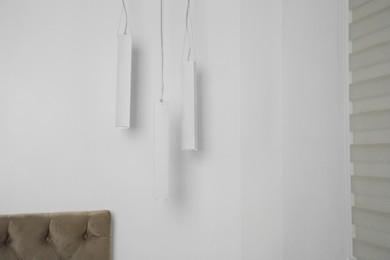 Photo of Stylish pendant lamps hanging in light room
