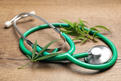Photo of Hemp leaves and stethoscope on wooden table