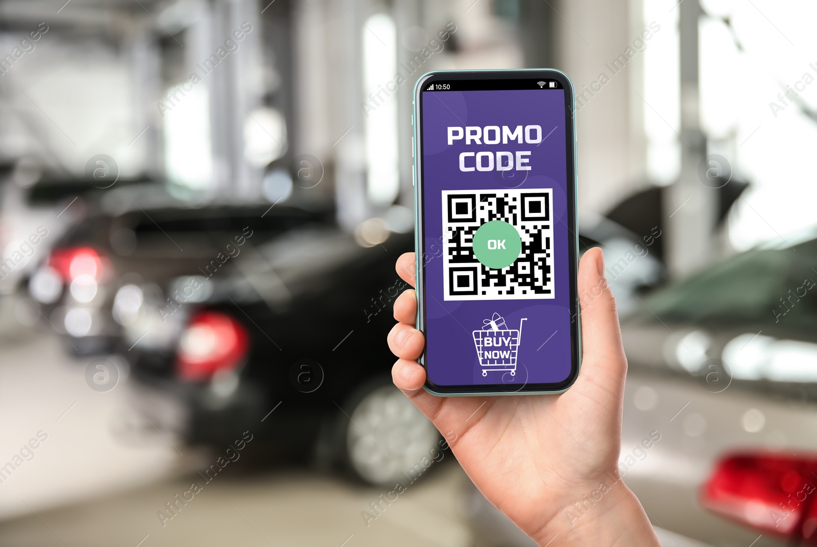 Image of Woman holding smartphone with activated promo code in car dealership, closeup