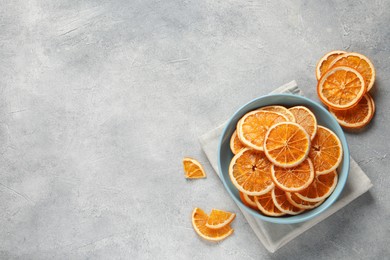 Photo of Many dry orange slices on grey textured table, flat lay. Space for text
