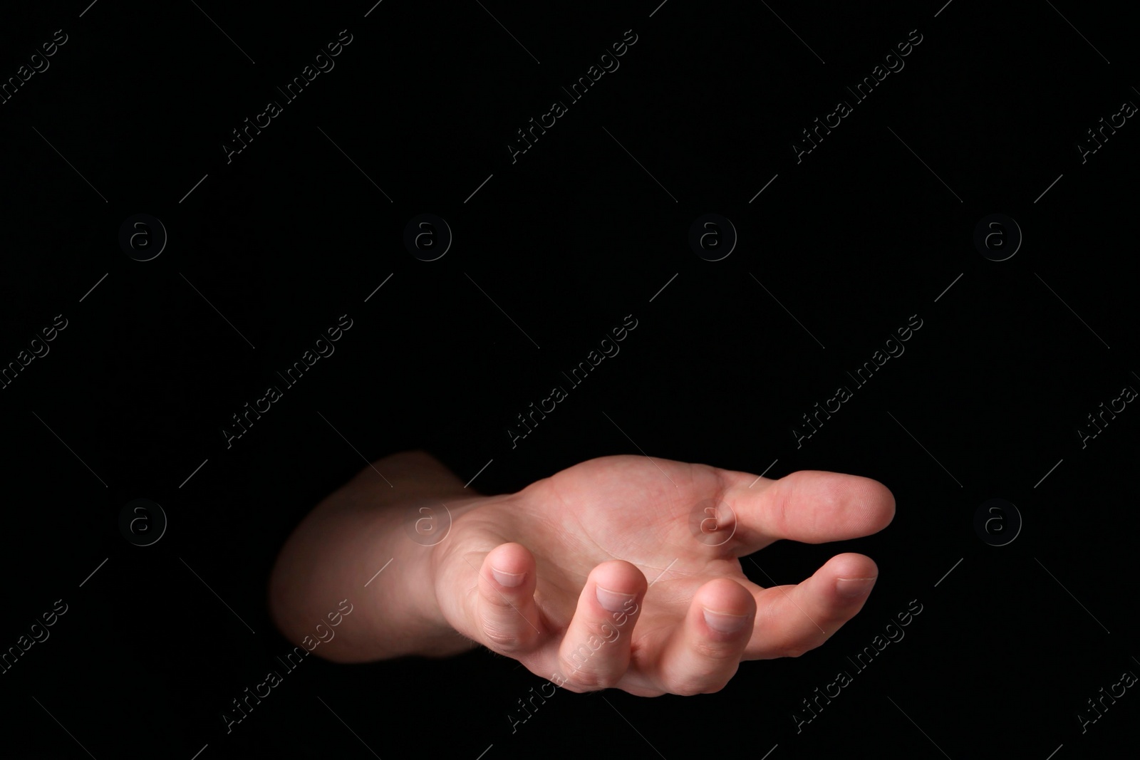 Photo of Man throwing game dices on black background, closeup. Space for text