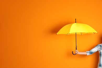 Photo of Woman holding beautiful umbrella on color background with space for design