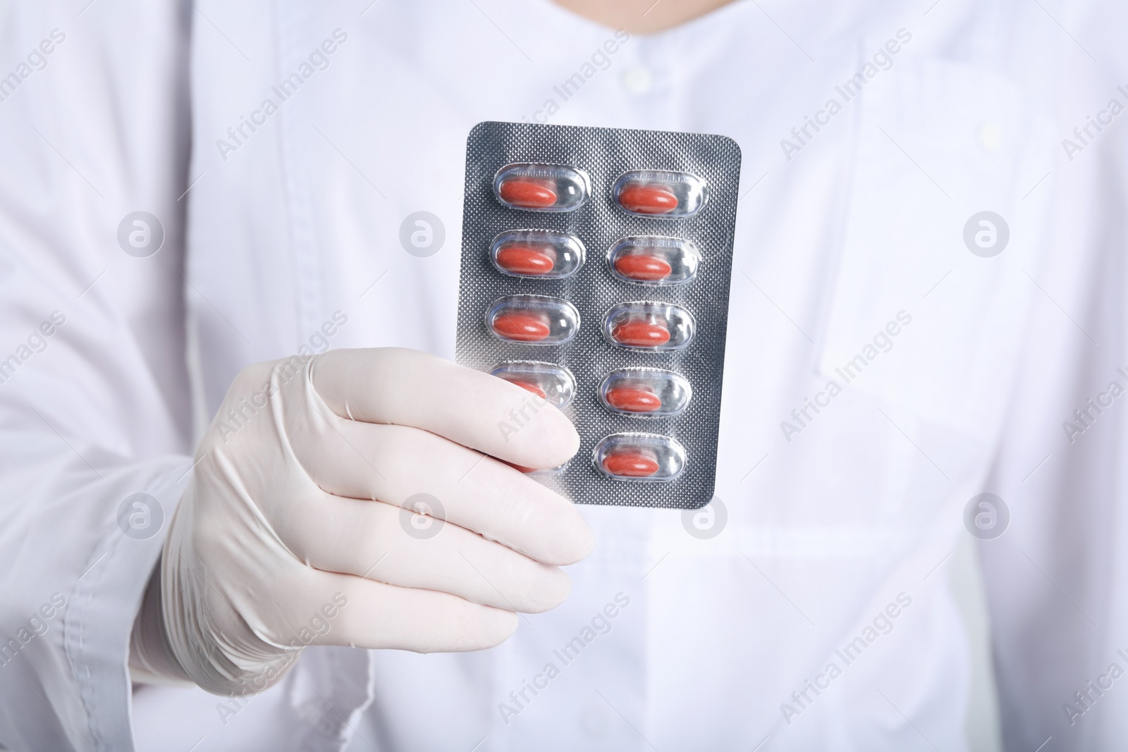 Photo of Doctor holding red pills, closeup. Anemia treatment