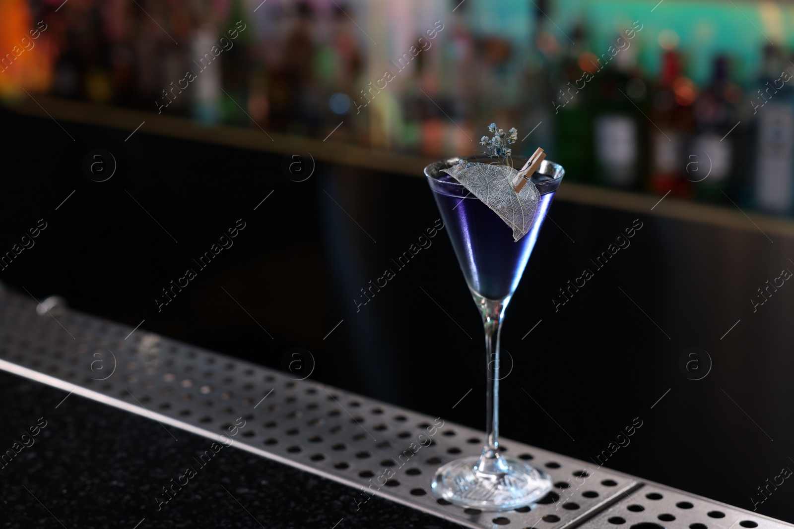 Photo of Fresh alcoholic cocktail in glass on bar counter. Space for text