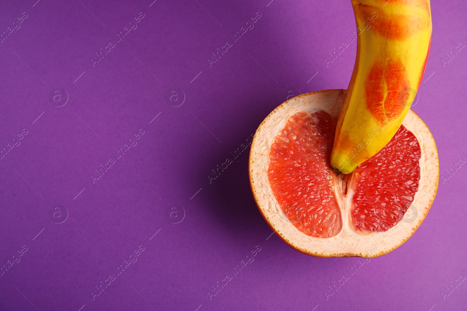 Photo of Flat lay composition with fresh banana and grapefruit on purple background, space for text. Sex concept