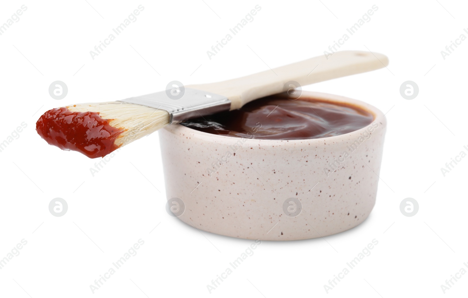 Photo of Marinade in bowl and basting brush isolated on white