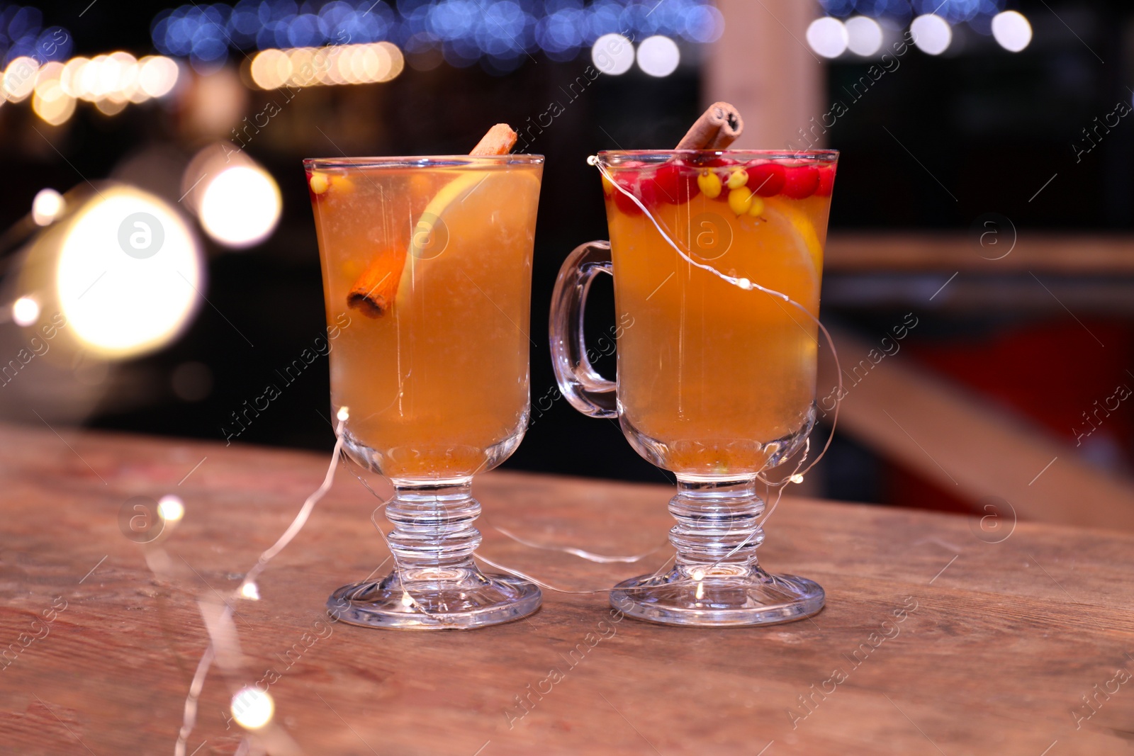 Photo of Tasty aromatic mulled wine on wooden table