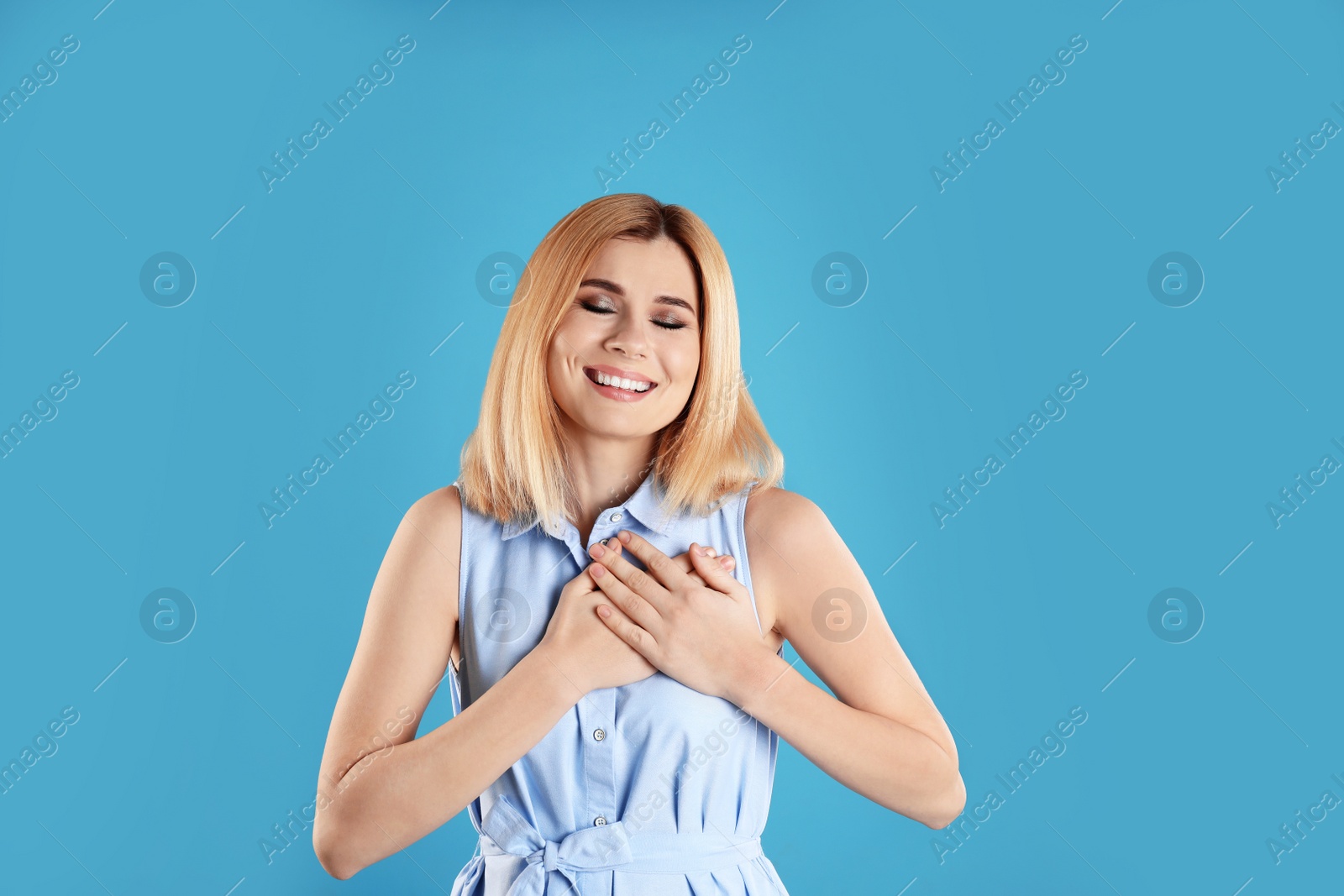 Photo of Portrait of woman holding hands near heart on color background