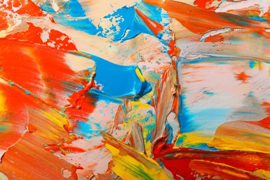 Photo of Closeup view of artist's palette with mixed bright paints as background