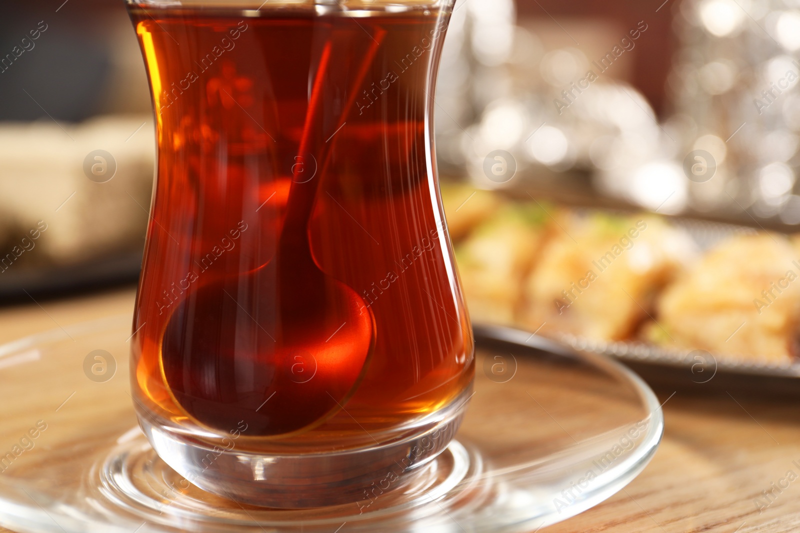 Photo of Traditional Turkish tea in glass on wooden table, closeup. Space for text