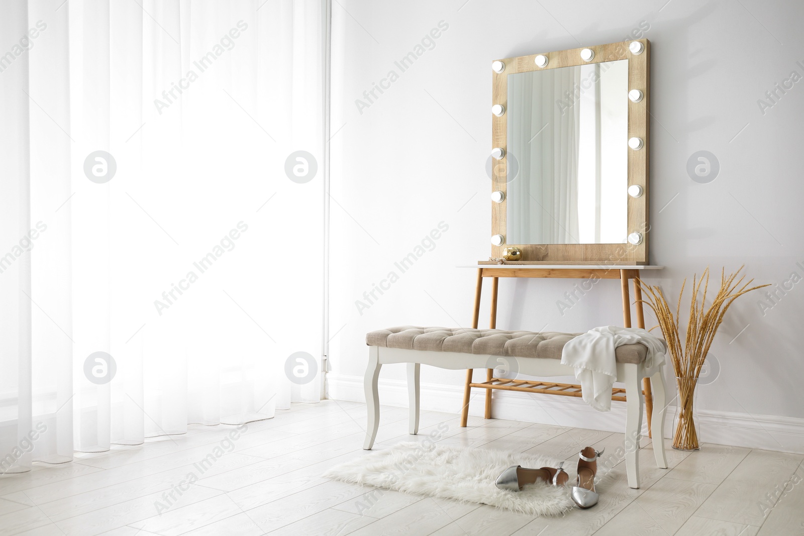 Photo of Stylish mirror with lamps near light wall in room