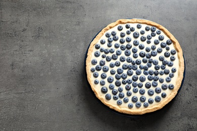 Tasty blueberry cake on gray background, top view with space for text