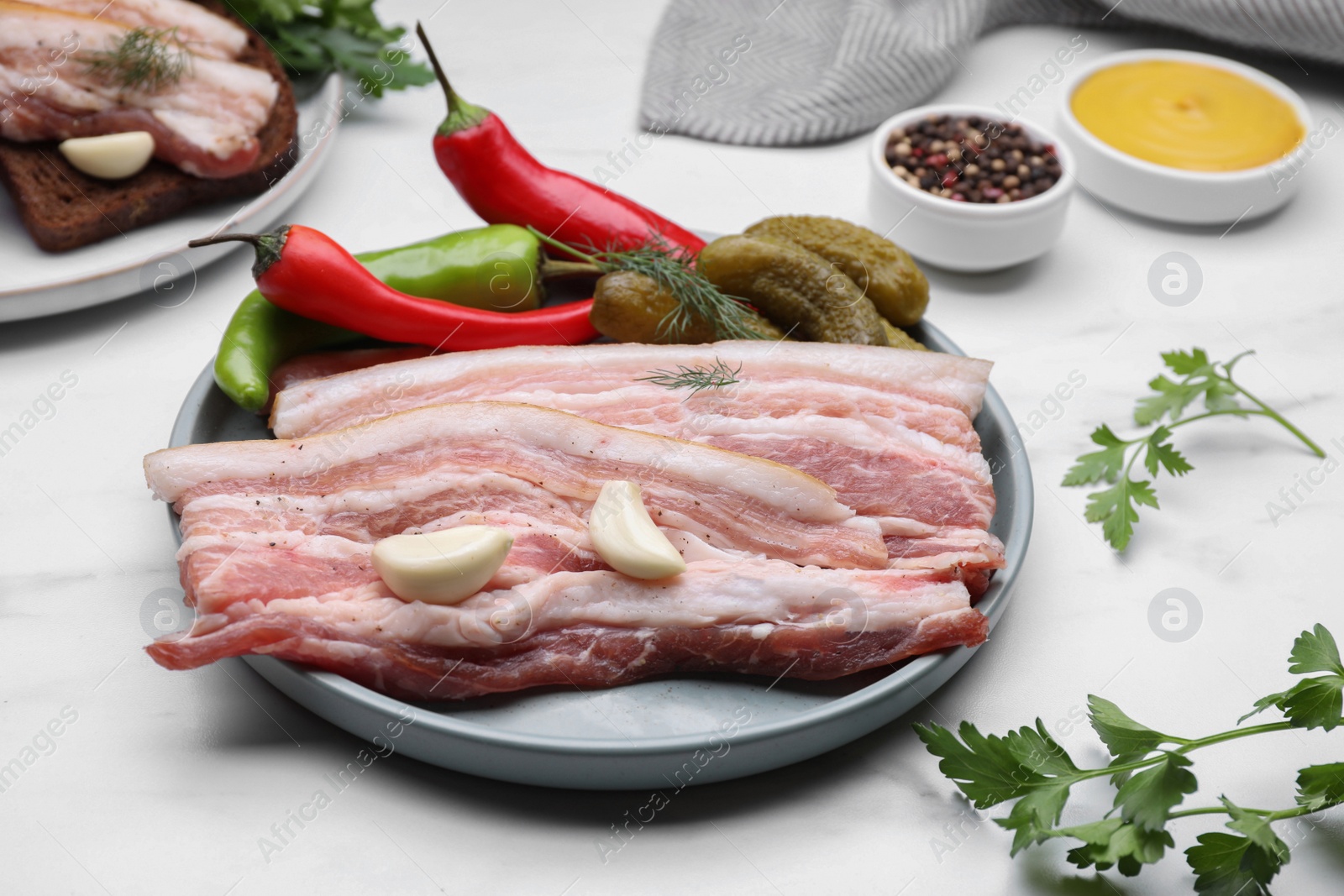 Photo of Tasty pork fatback served on white marble table