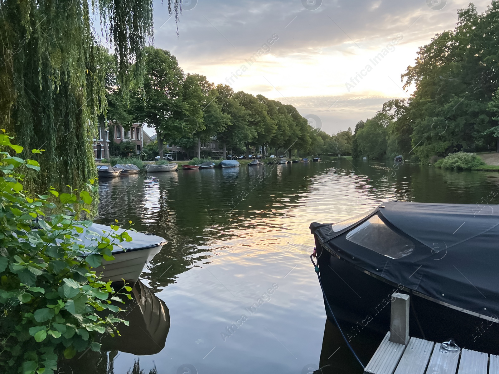 Photo of Picturesque view of river with moored boats in evening