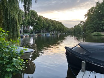 Photo of Picturesque view of river with moored boats in evening