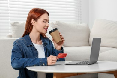 Photo of Happy woman with credit card near laptop at home, space for text. Online shopping