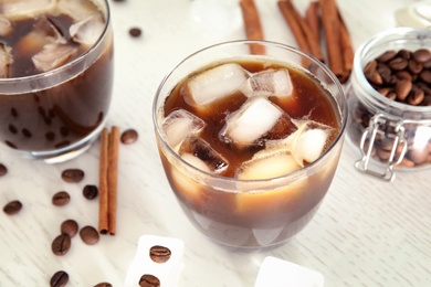 Glass of coffee drink with ice cubes on table