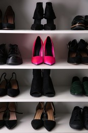 Pink shoes among others on shelving unit. Diversity concept