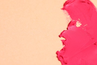 Photo of Smears of beautiful lipstick on beige background, closeup. Space for text