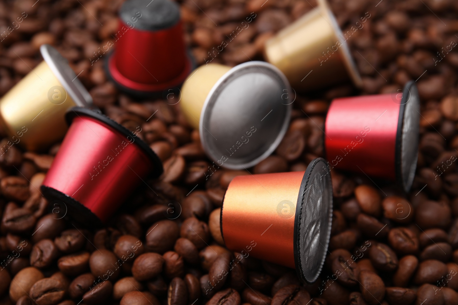 Photo of Many different coffee capsules on beans, closeup