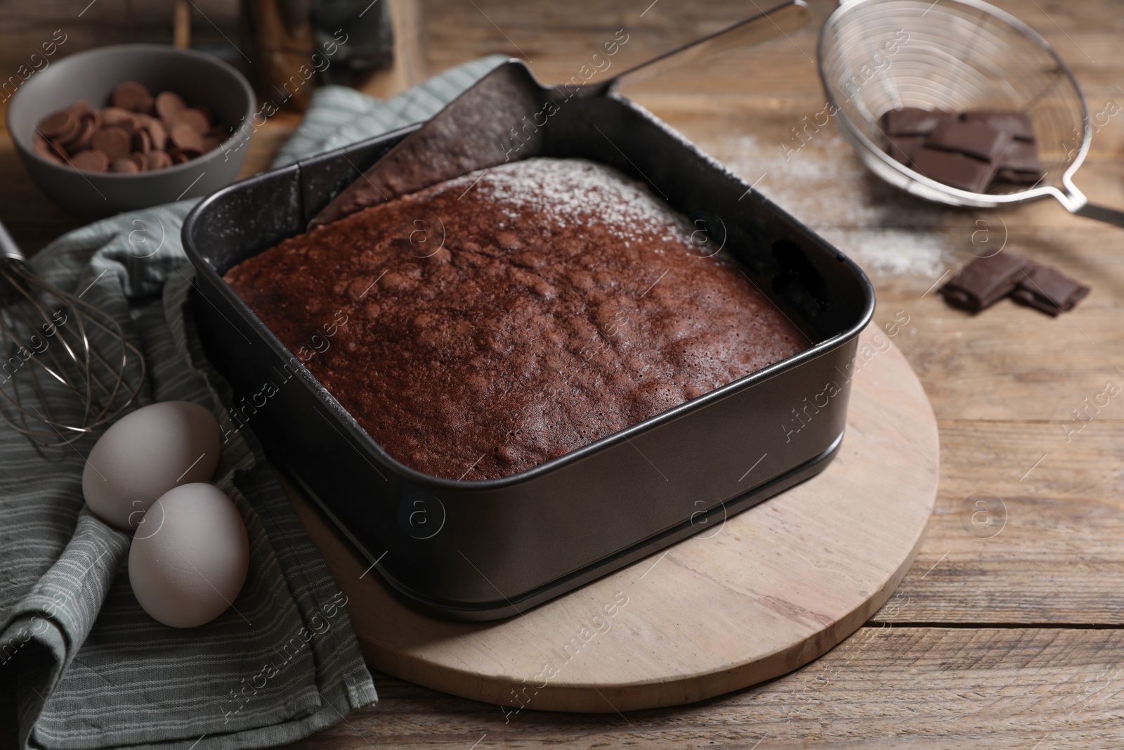 Photo of Homemade chocolate sponge cake and ingredients on wooden table