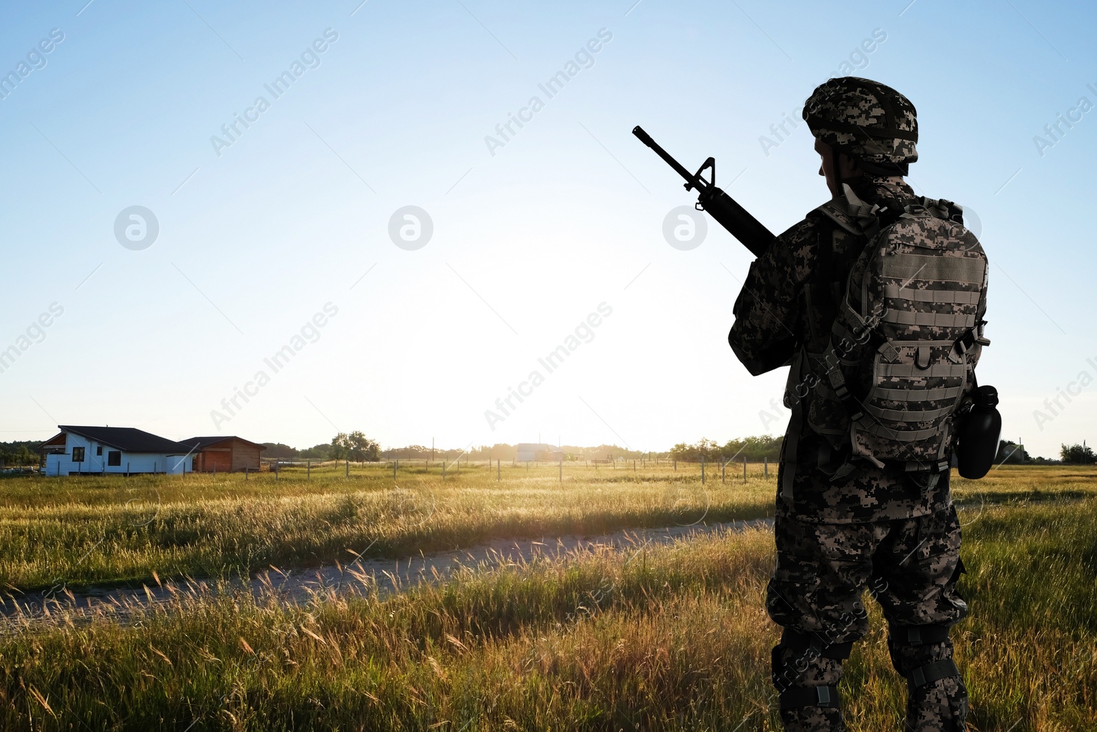 Image of Soldier with machine gun outdoors, back view