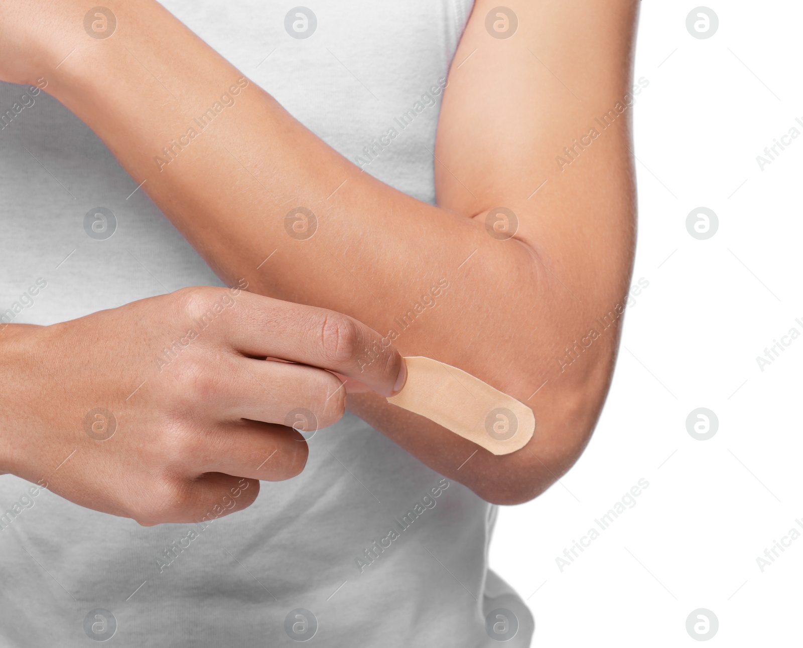 Photo of Man putting sticking plaster onto elbow on white background, closeup