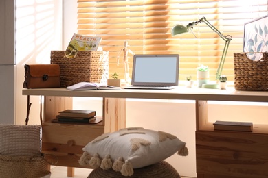 Photo of Comfortable workplace with laptop near window at home