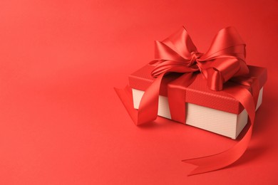 Photo of Beautiful gift box with bow on red background. Space for text