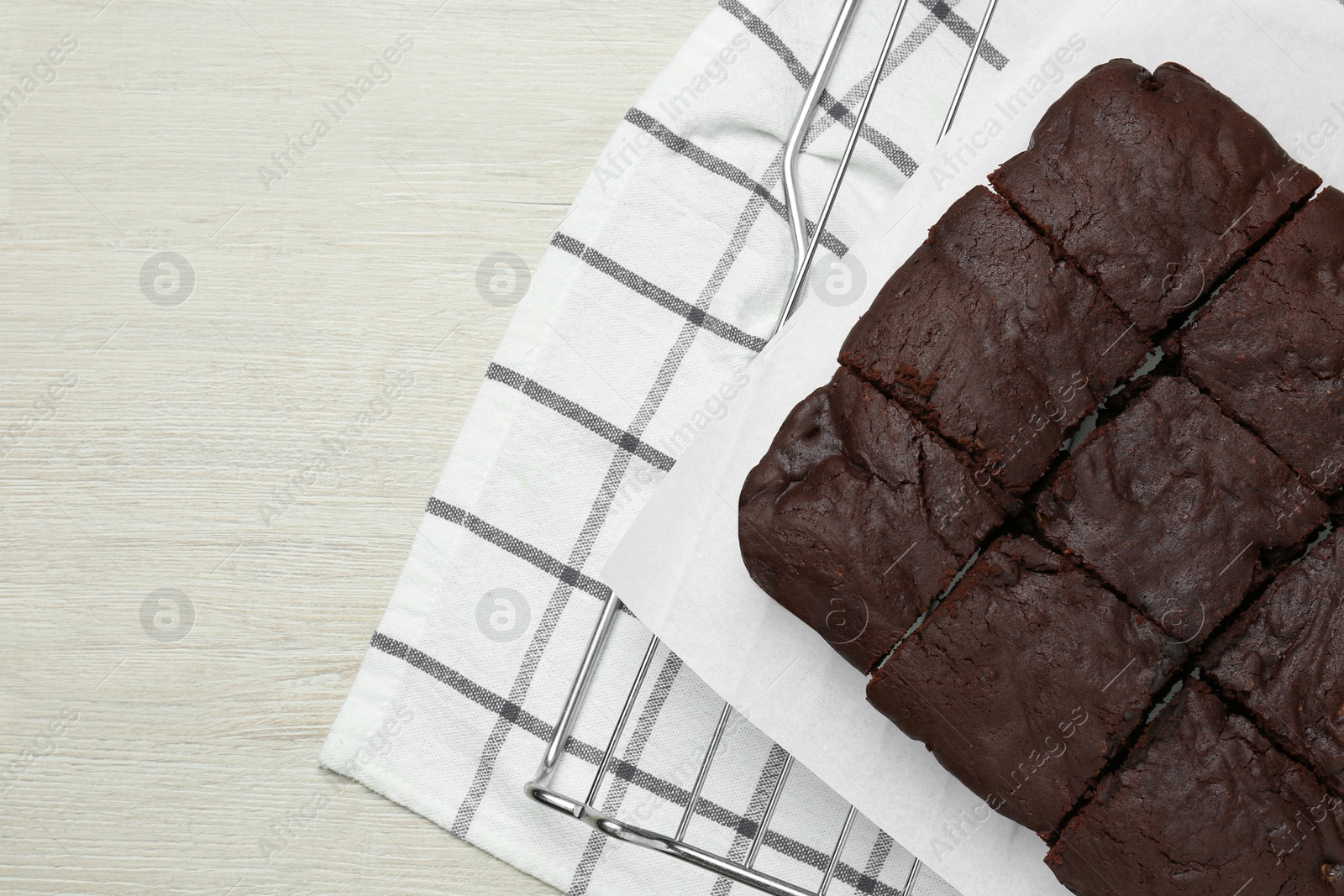 Photo of Delicious freshly baked brownies on white wooden table, top view. Space for text