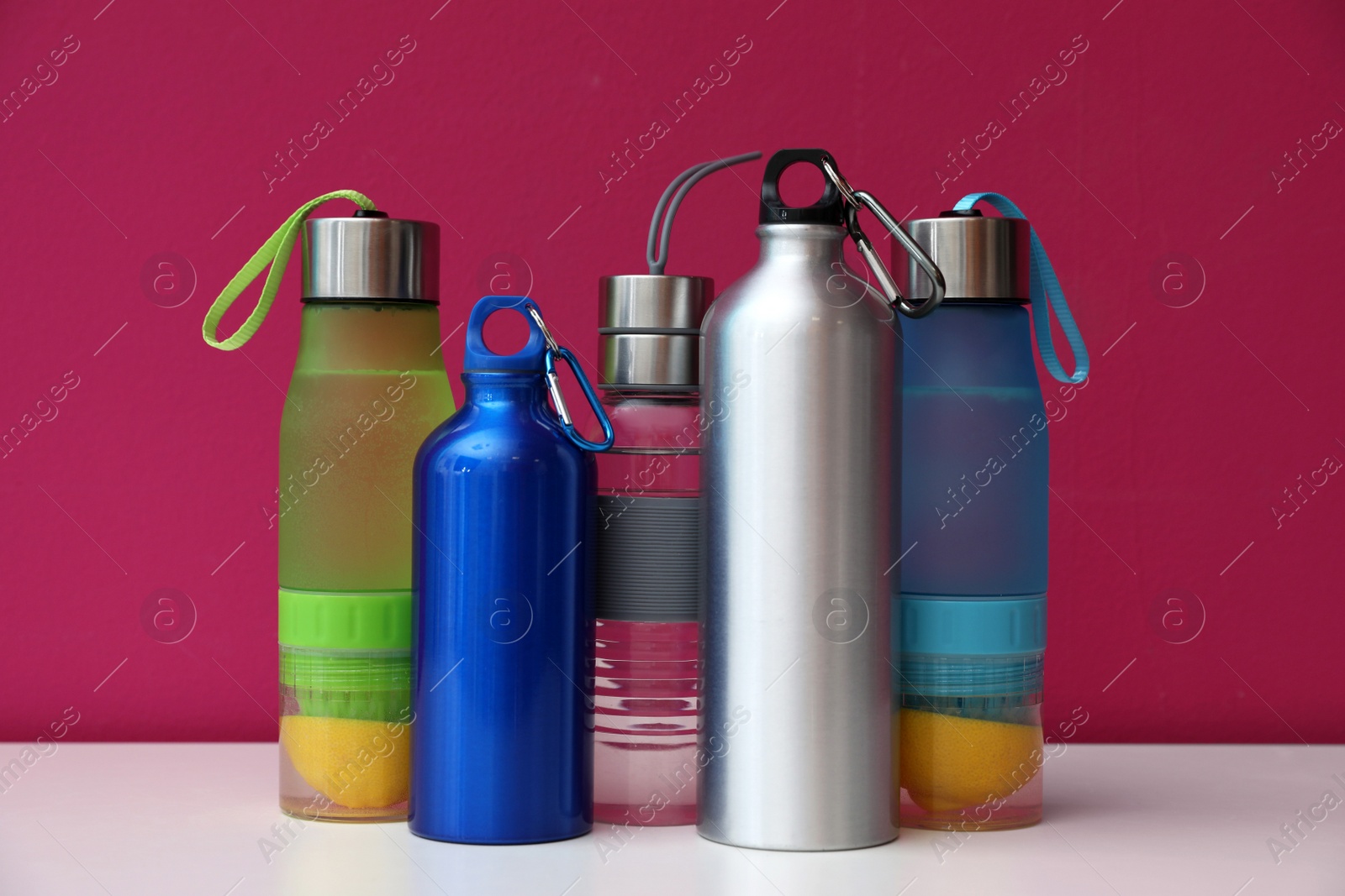 Photo of Different water bottles for sports on color background